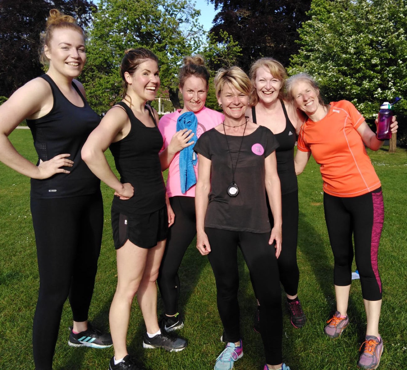 Lucie Collins outdoors with a group of women after a training session on the grass